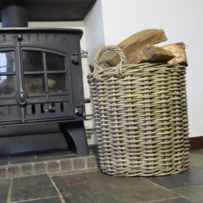 Ronde houtmand bij de openhaard